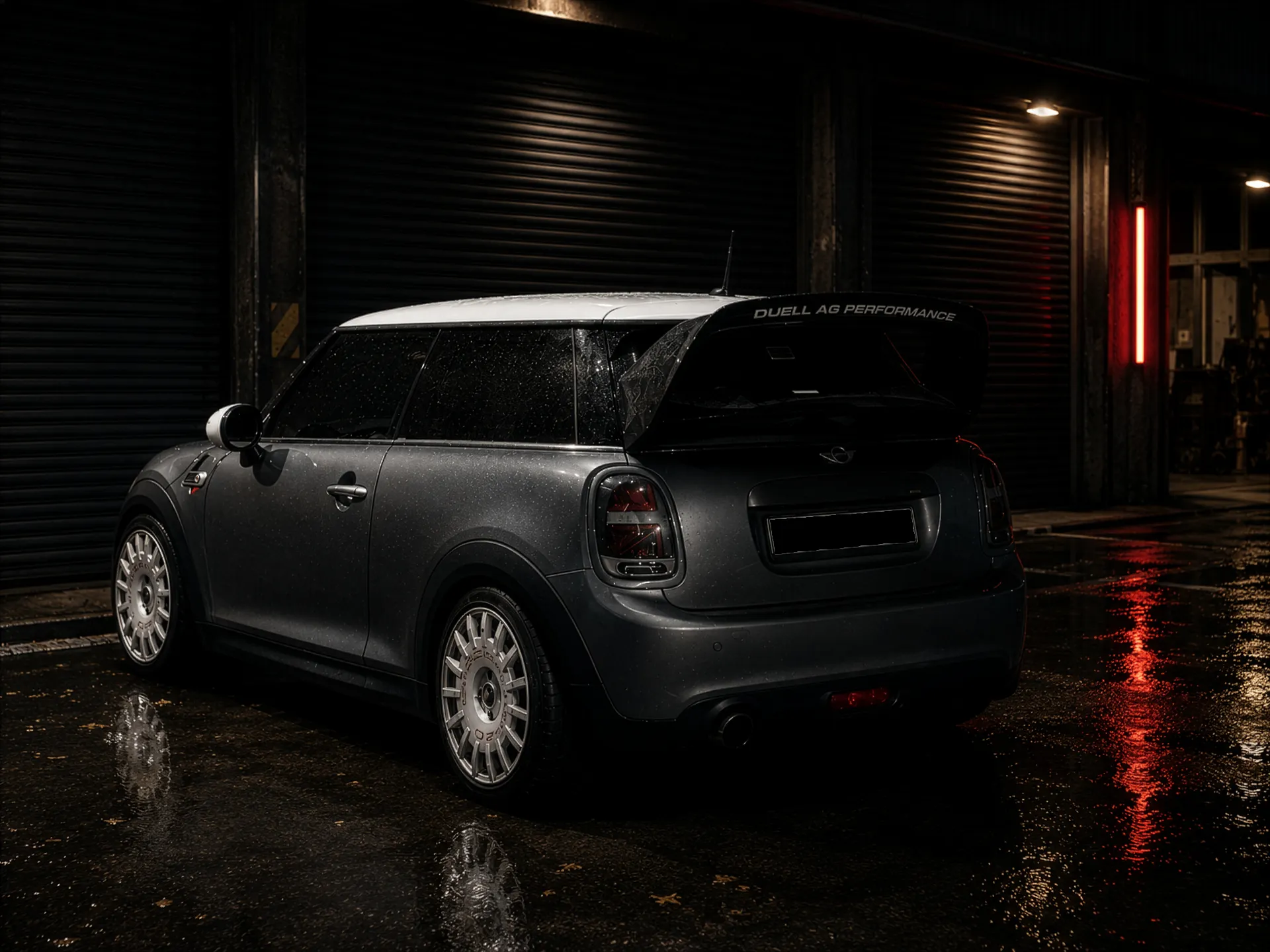 Grey Mini parked outside a dark workshop shutter at night